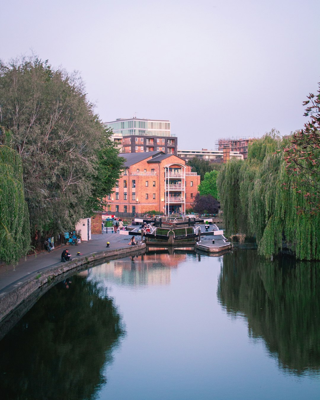 brown and white concrete building near green trees and river during daytime