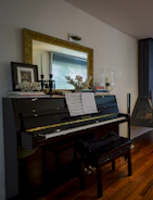 black upright piano near brown wooden framed mirror