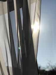 Bright, freshly cleaned curtains hanging by a sunny window.