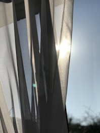 A serene morning scene with soft sunlight filtering through calming blue curtains.