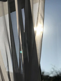 Bright room overlooking the sea with sheer curtains fluttering in the breeze.