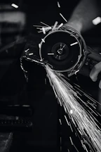Angle grinder in action, sparks flying as it cuts through metal.