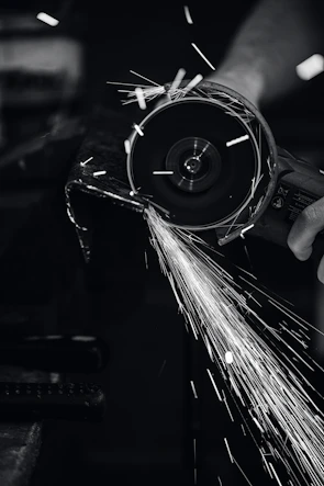 Angle grinder in action, sparks flying as it cuts through metal.