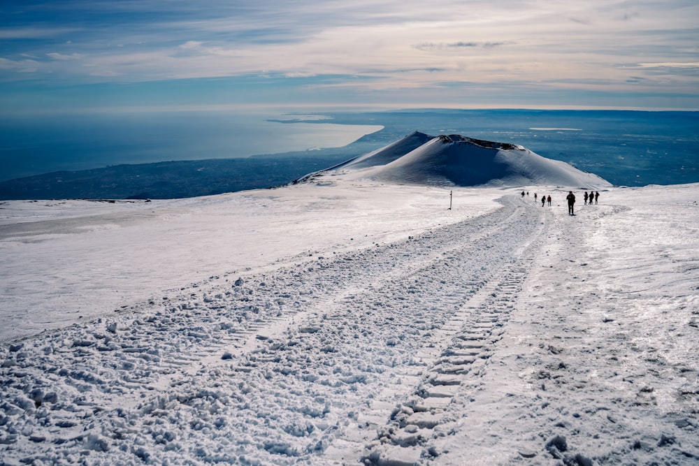 a group of people walking up a snow covered hill