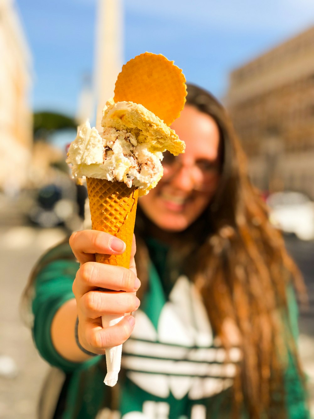 mujer sosteniendo cono de helado con helado amarillo