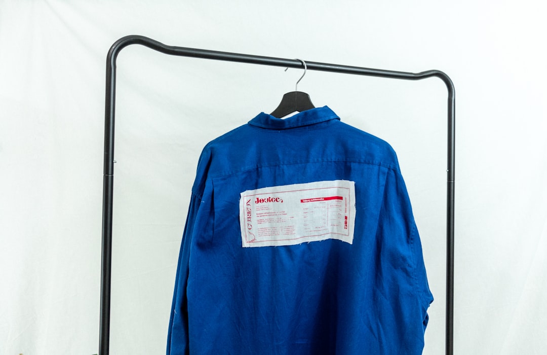 blue long sleeve shirt hanging on black plastic clothes hanger