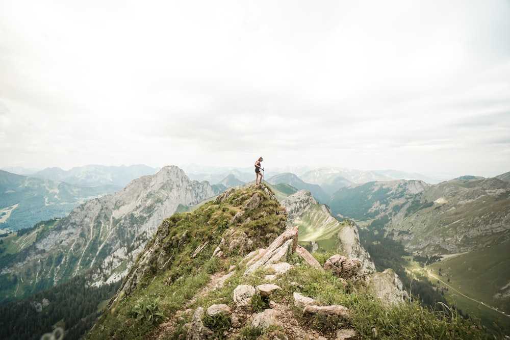 person standing on rocky mountain during daytime