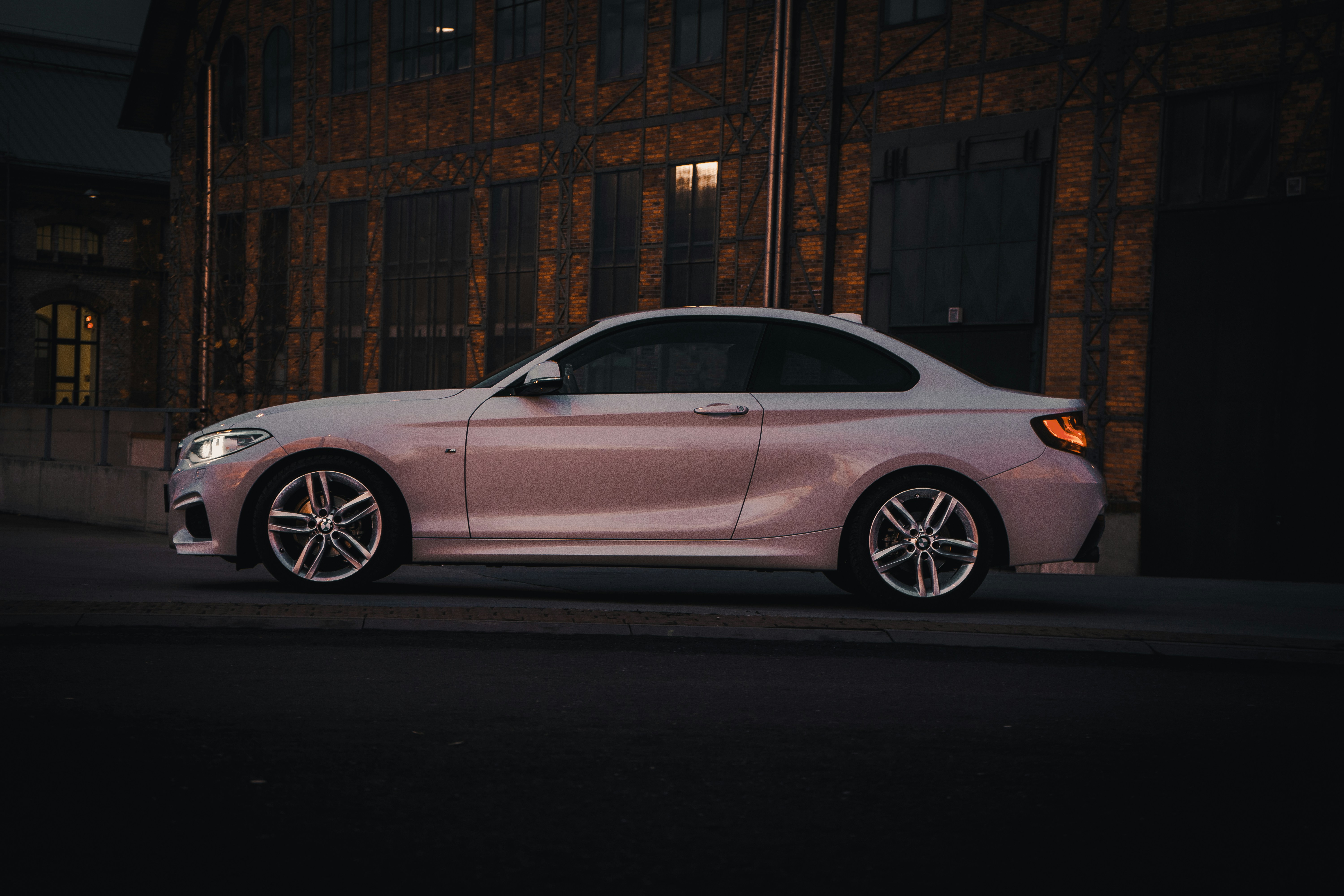 white sedan parked near brown building