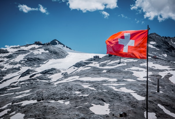 red flag on white snow covered mountain during daytime