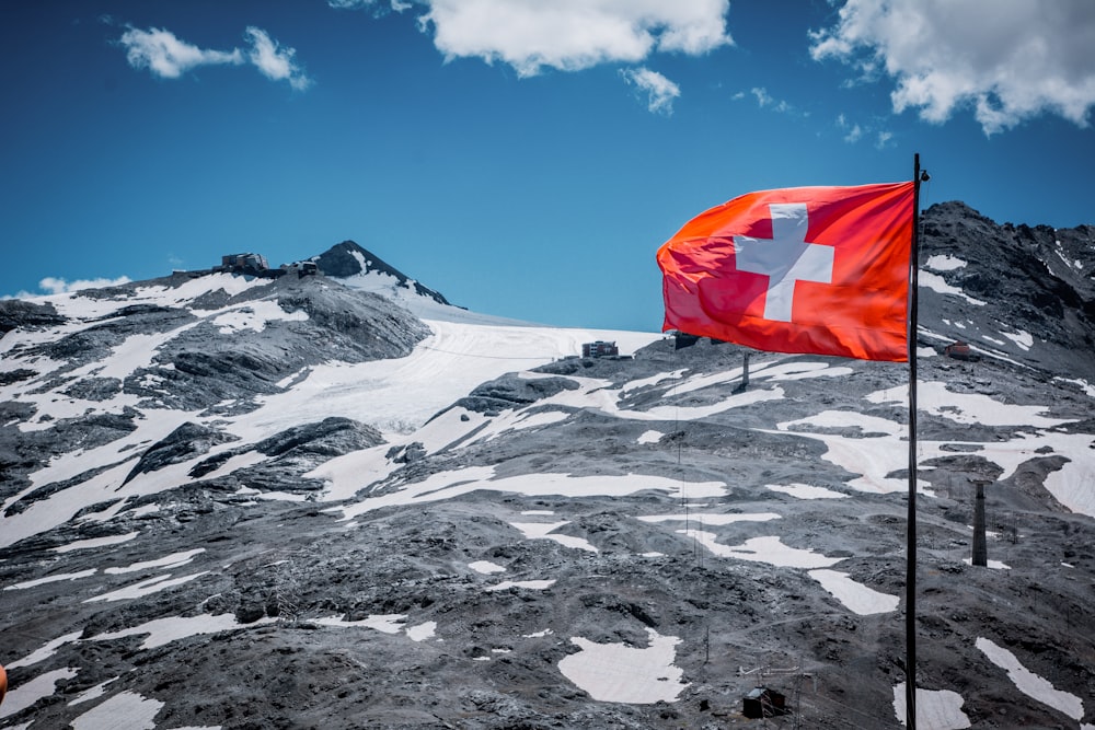 drapeau rouge sur la montagne enneigée blanche pendant la journée