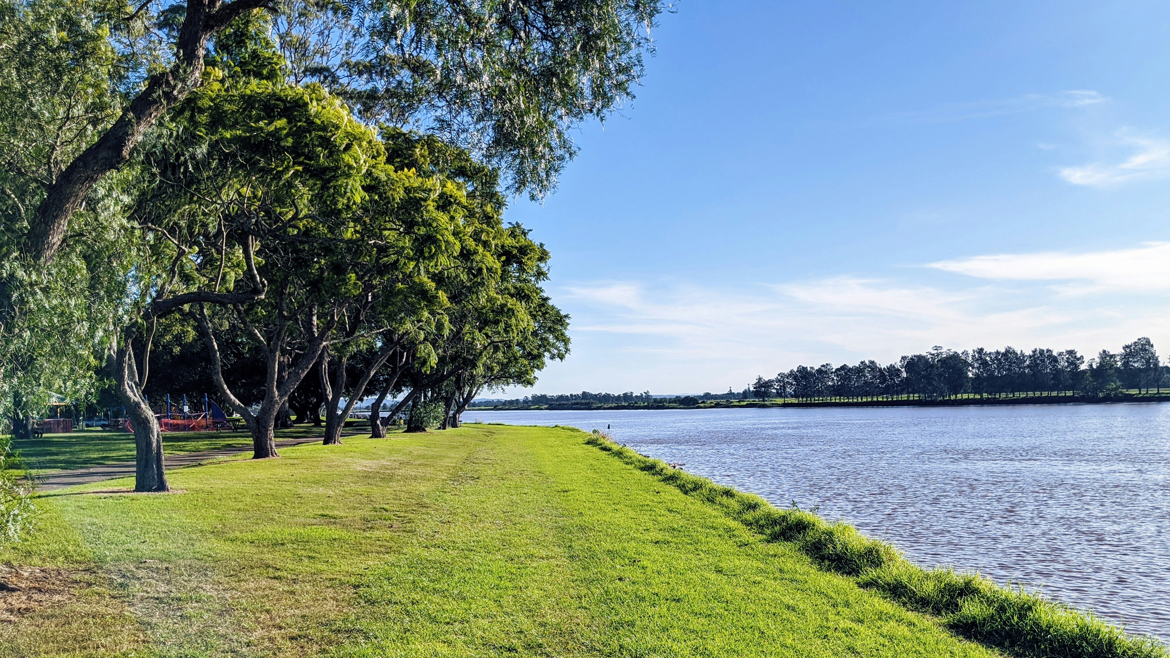 a grassy area next to a body of water