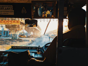 A driver assisting factory personnel as they get on a comfortable transport bus