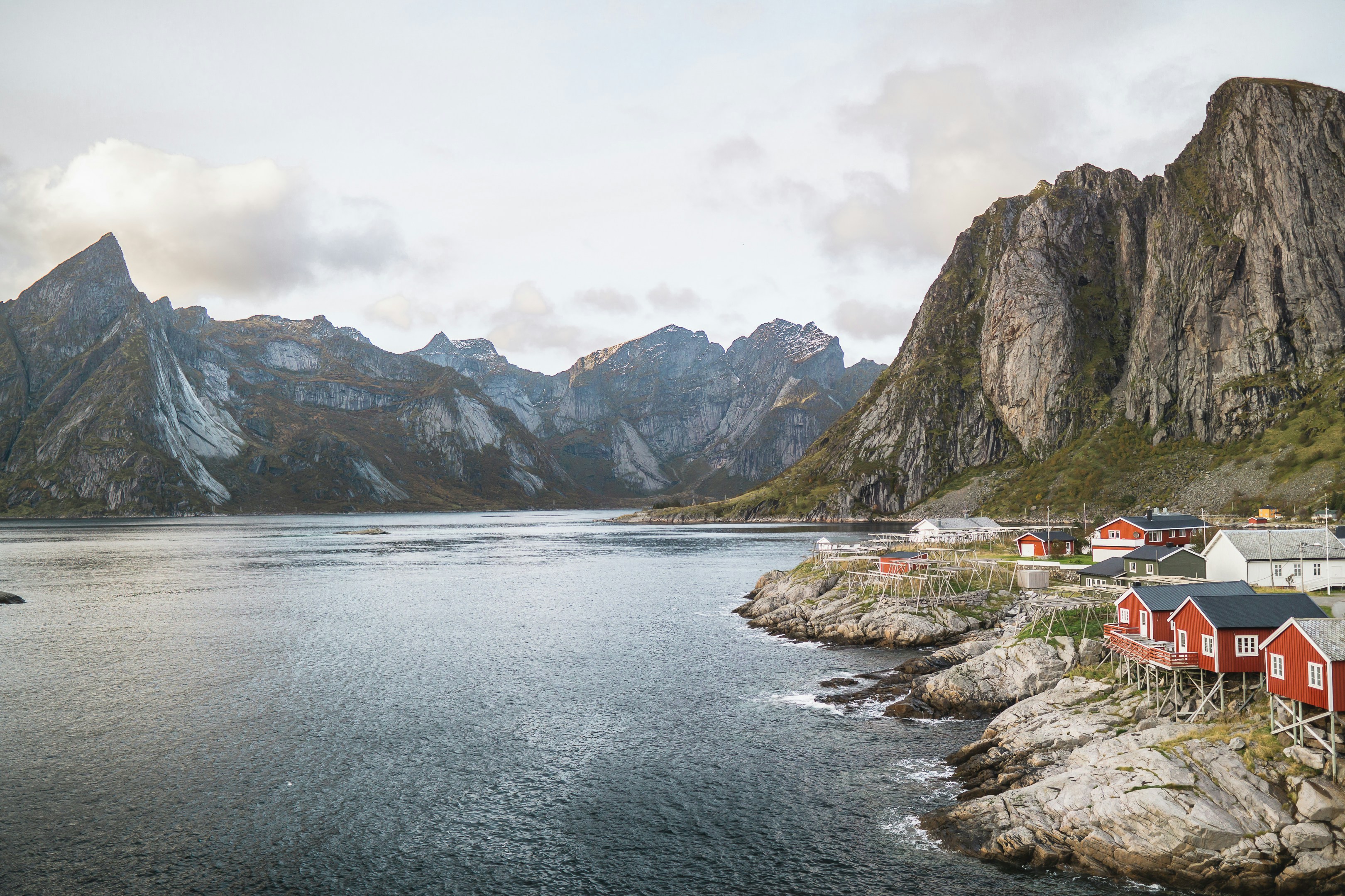 body of water near mountain under cloudy sky during daytime, 