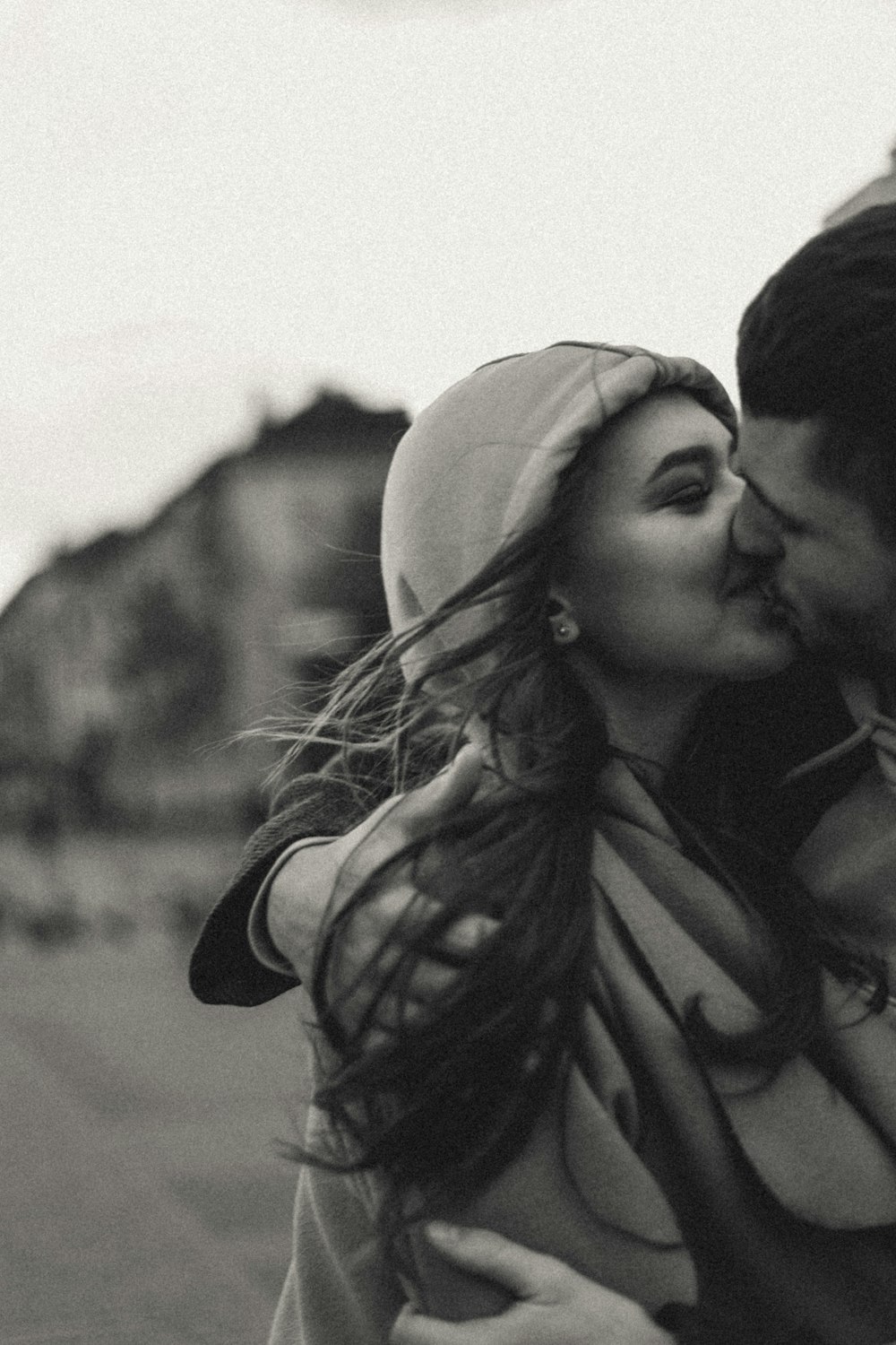 여자 이마에 키스하는 남자의 회색조 사진