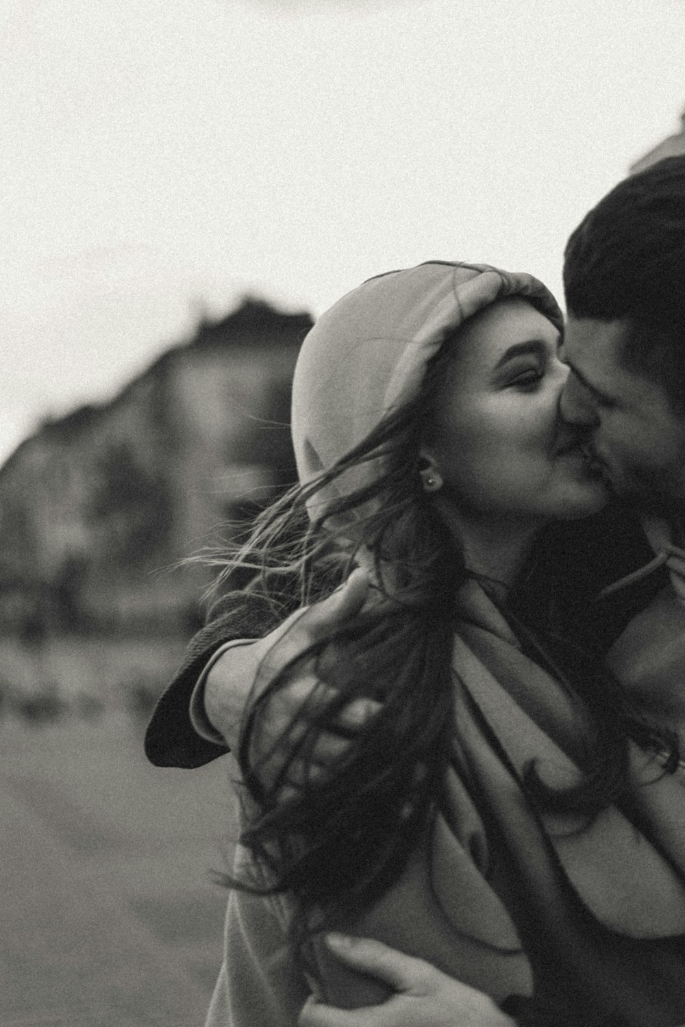 grayscale photo of man kissing womans forehead