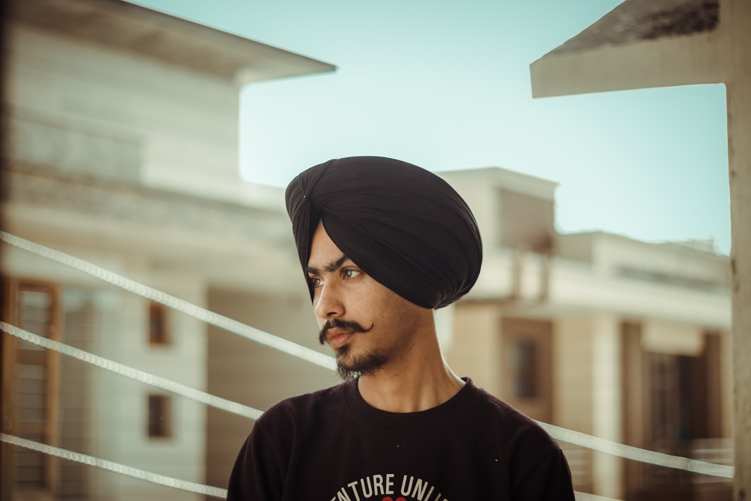 man in black crew neck shirt wearing black cap