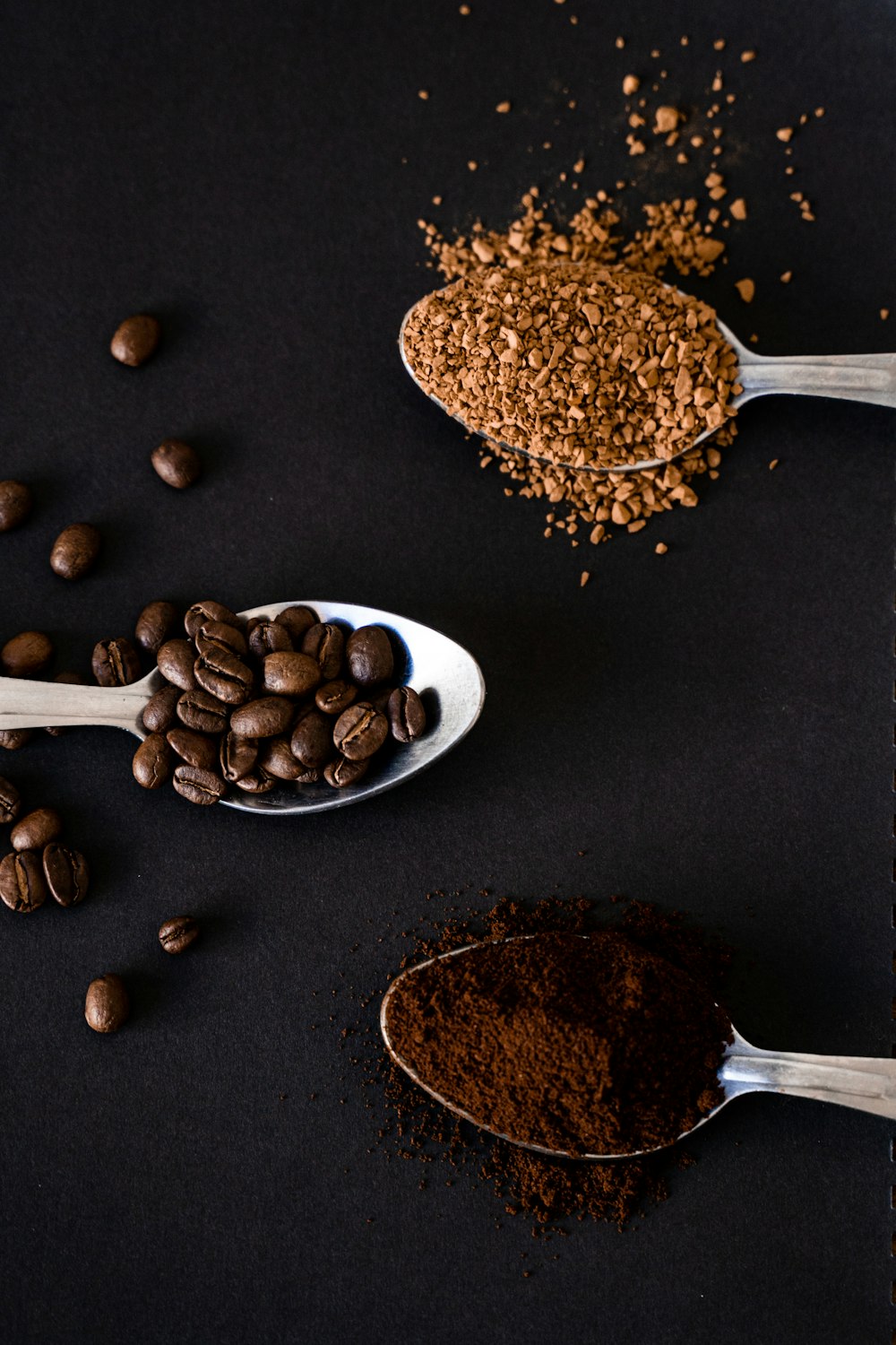 brown coffee beans on silver spoon