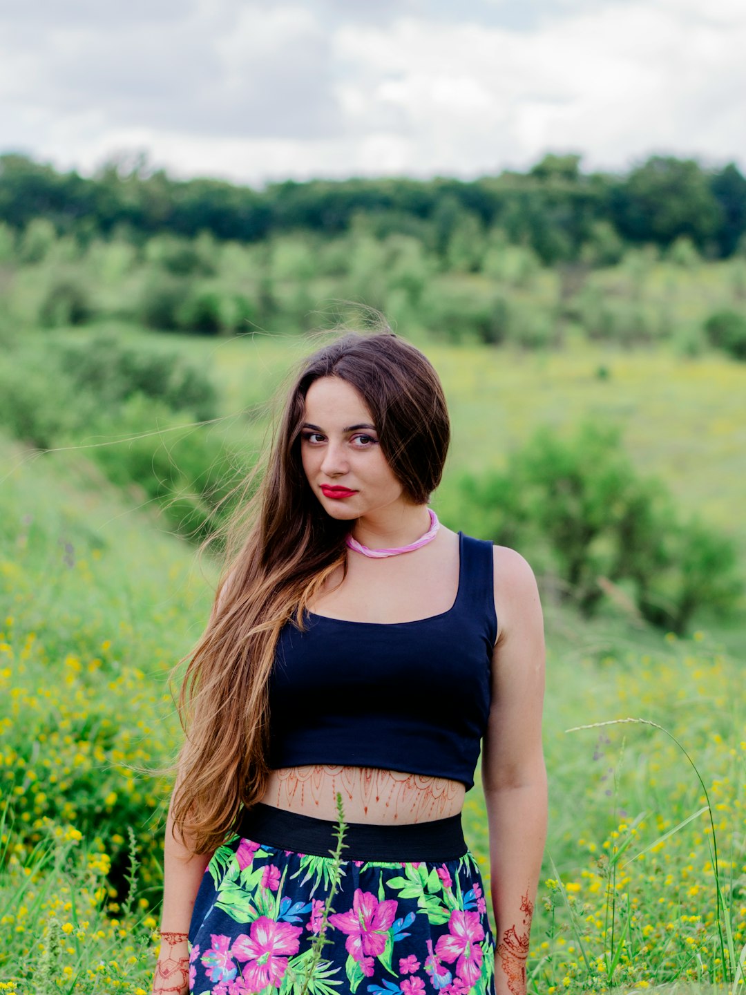 woman in blue tank top standing on green grass field during daytime