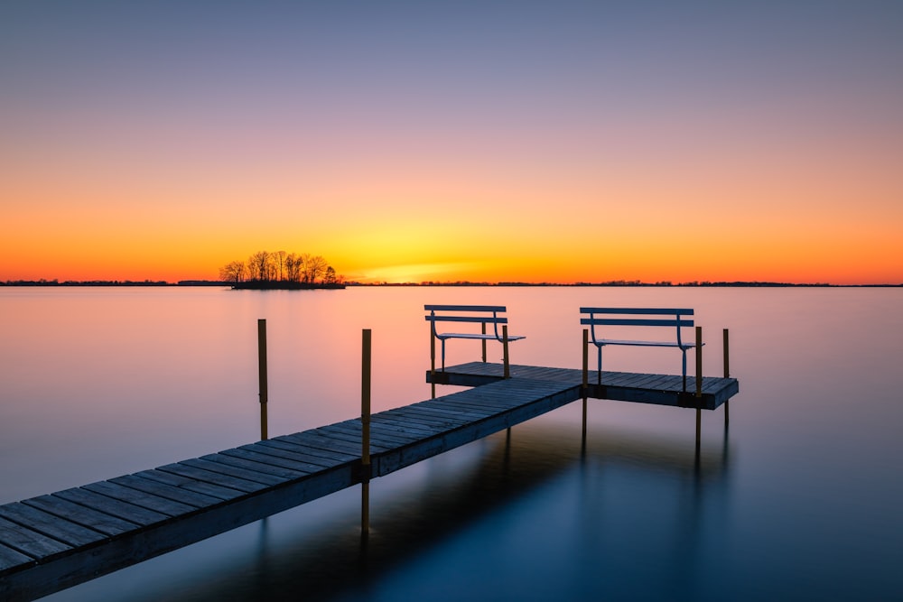 Braunes Holzdock auf dem Gewässer während des Sonnenuntergangs