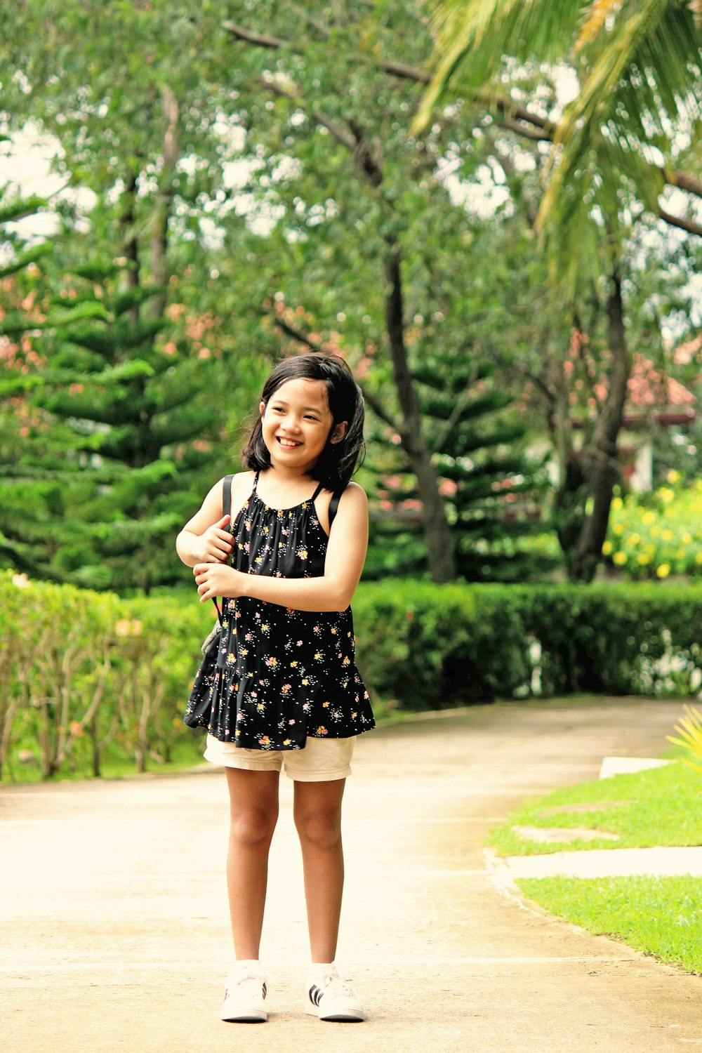 woman in black and white polka dot dress standing on pathway