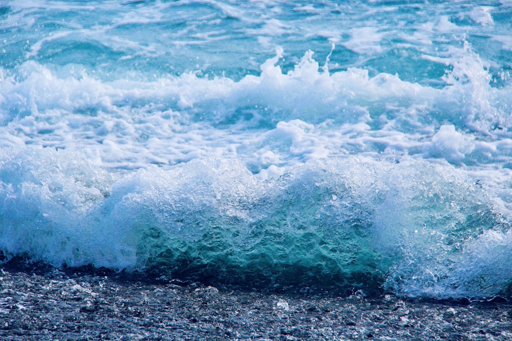 water waves on black sand during daytime