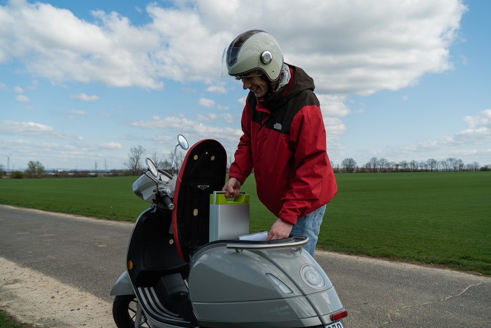 man in red jacket riding on motorcycle during daytime