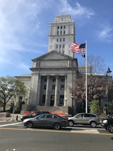 A modern courthouse building with clear signage and a flag waving in front.