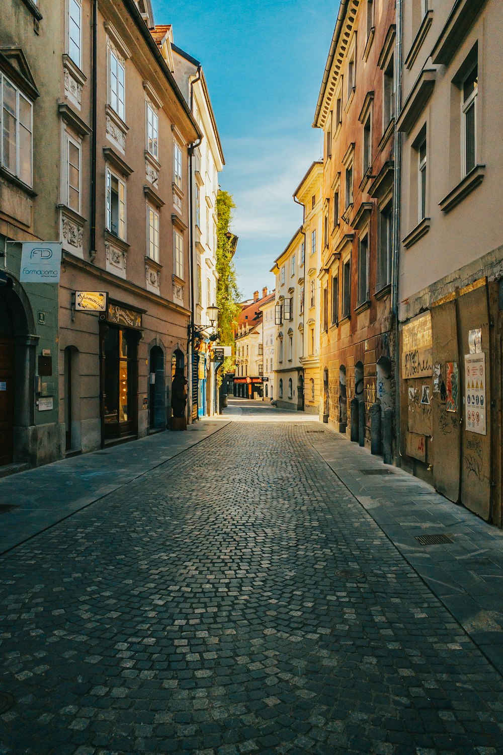 leere Straße zwischen braunen Betongebäuden tagsüber