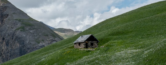 black and gray house on green grass field near mountain under white clouds during daytime in Valloire France