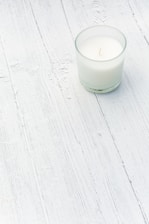 A minimalist display of three candles in white, black, and pink on a sleek surface.