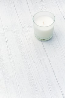Softly lit candles on a simple white bone surface, evoking tranquility and focus