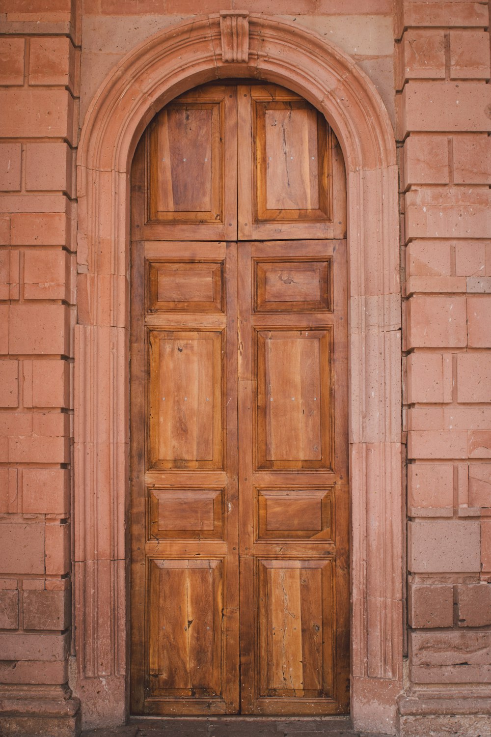 Porta di legno marrone su muro di mattoni marroni