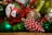 A collection of colorful Christmas ornaments including a red bauble with a snowman design, a green and gold textured ornament, and a pinecone-shaped decoration painted red and white.