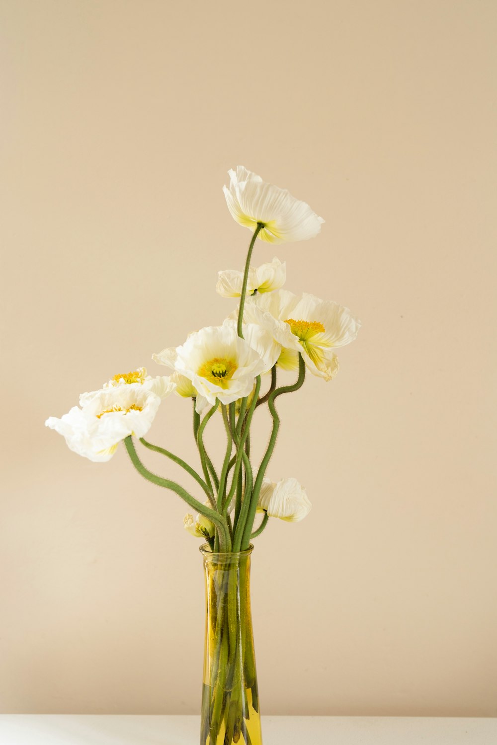 a glass vase filled with white flowers on top of a table