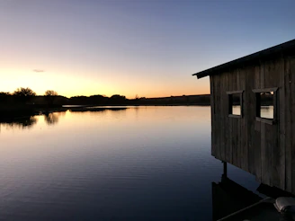 A peaceful sunset scene by a lake near one of our UK properties, with calm waters reflecting the sky.