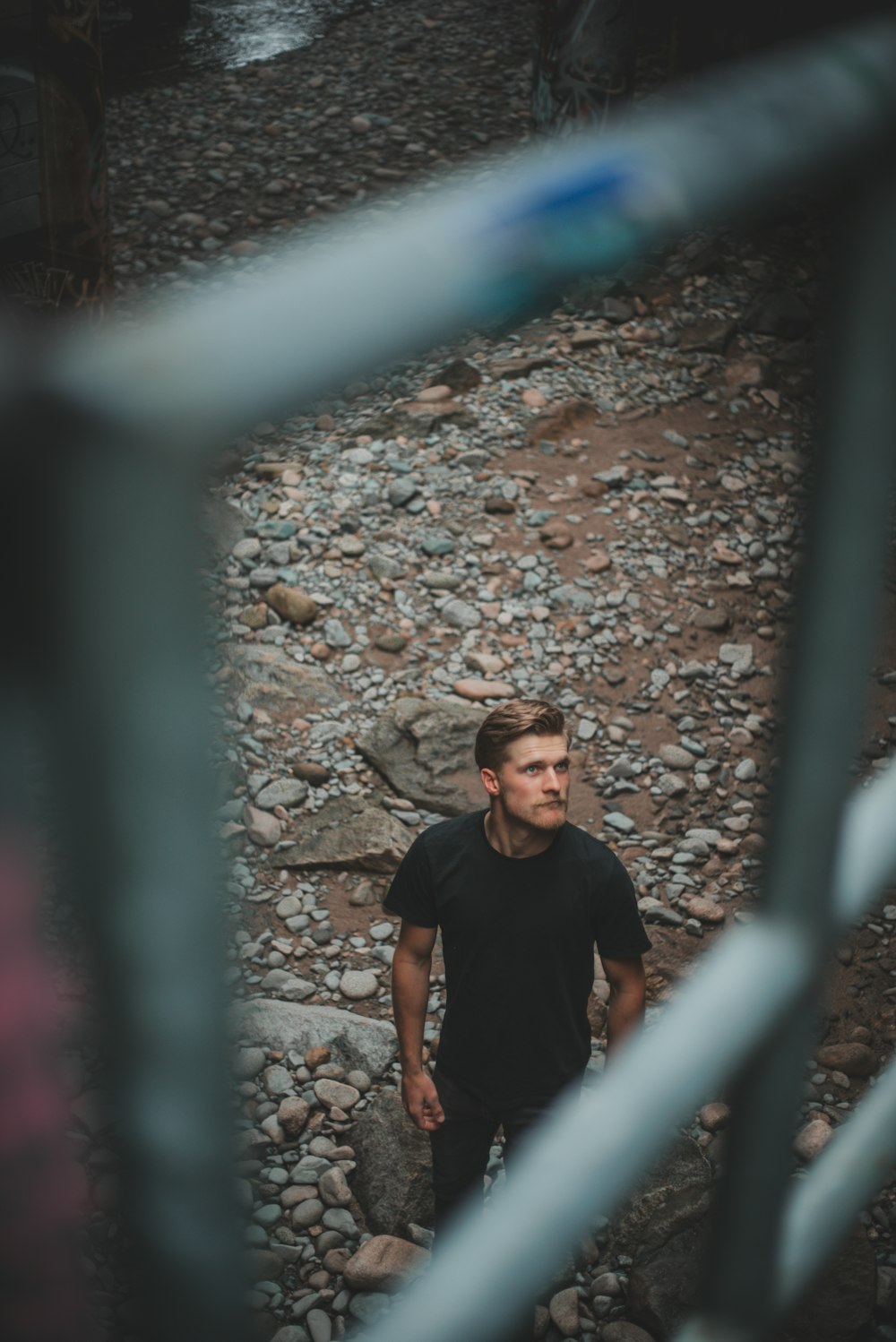 man in black crew neck t-shirt standing on rocky ground during daytime