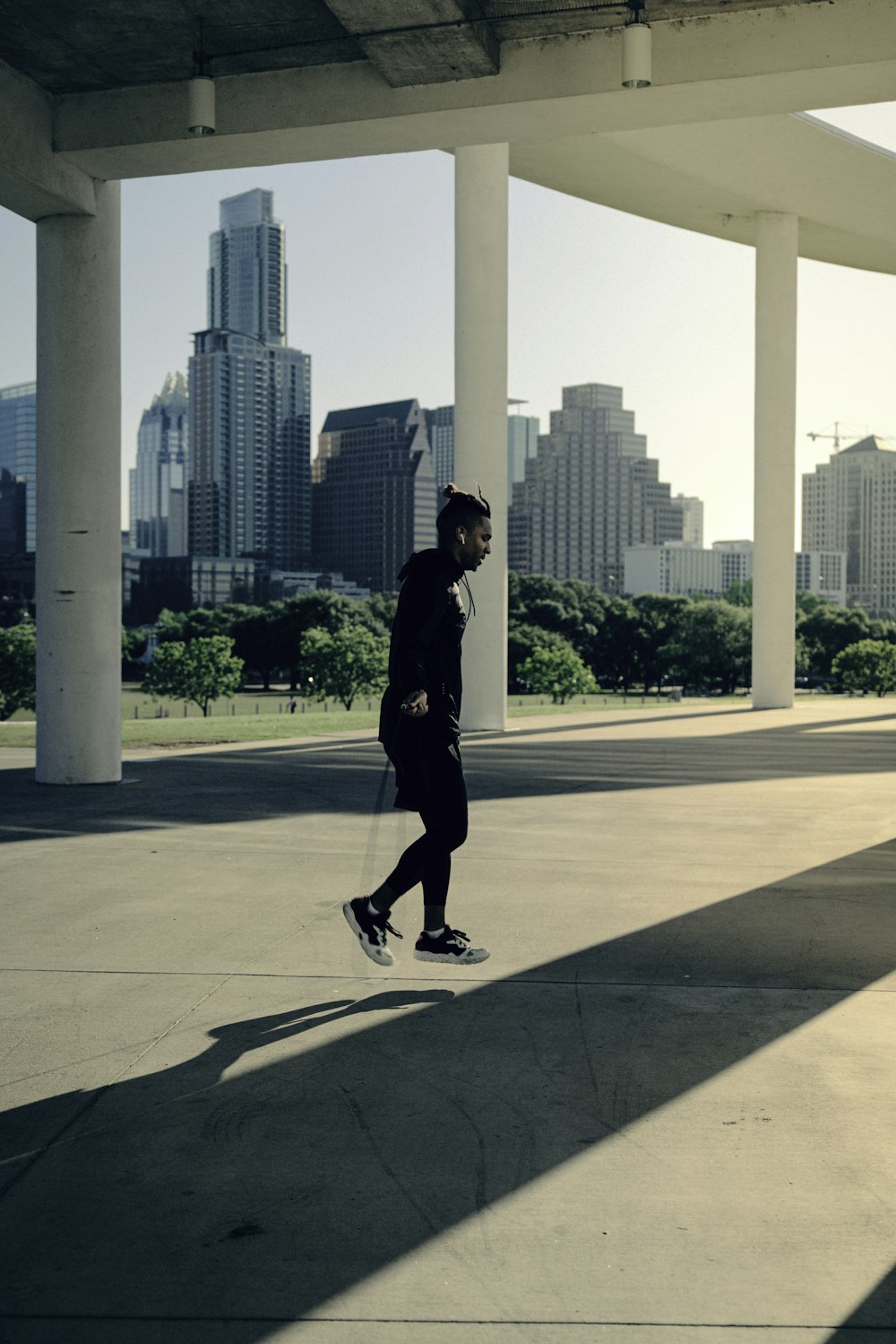 man in black jacket and pants standing on gray concrete pavement during daytime