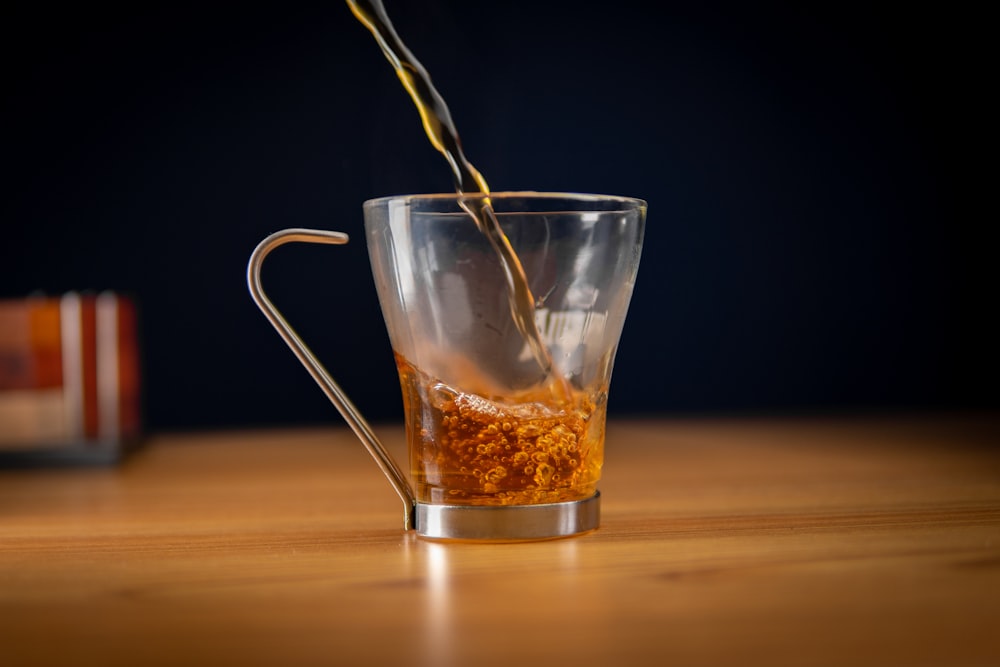 clear glass mug with brown liquid