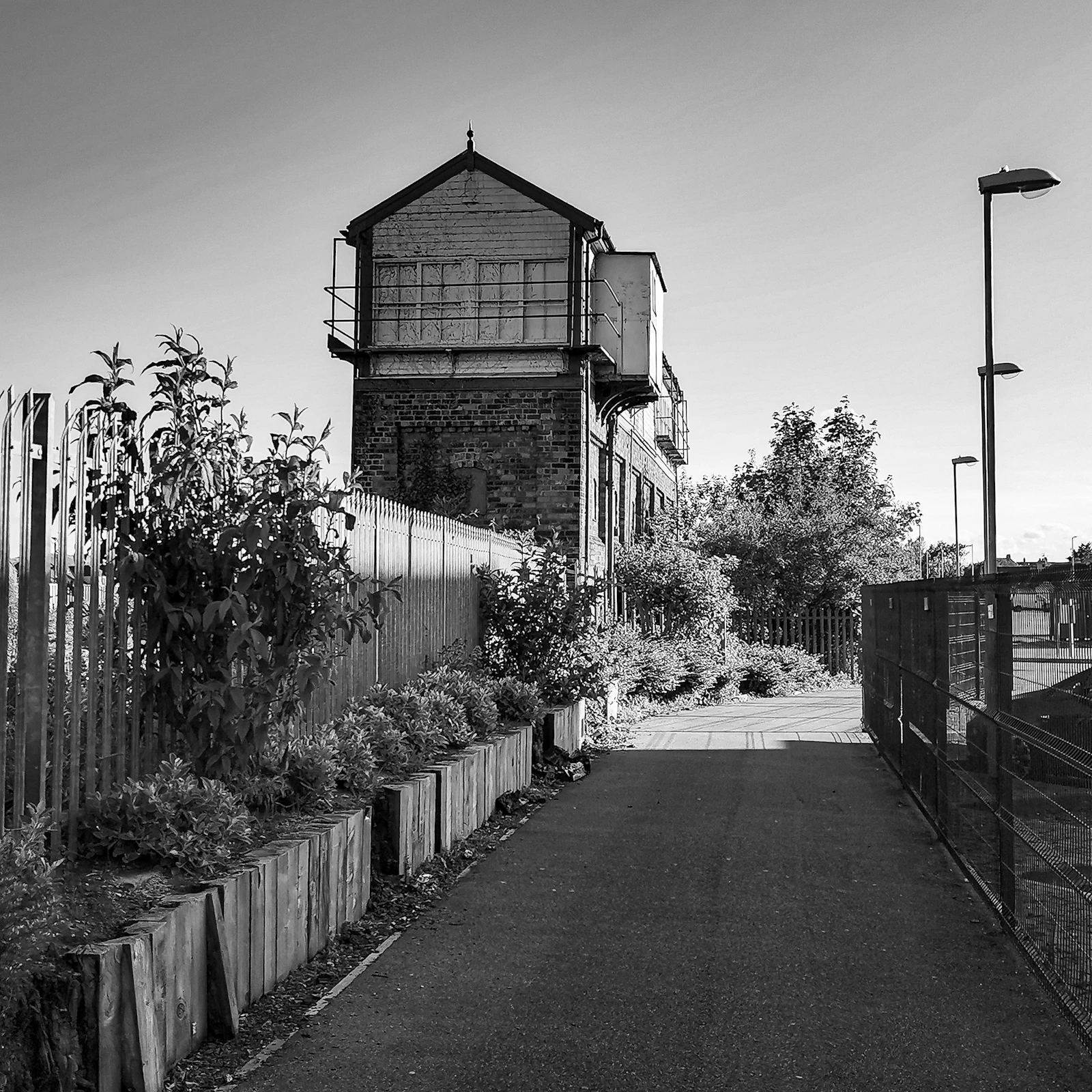 A traditional railway signal box beside the line, seen in black and white