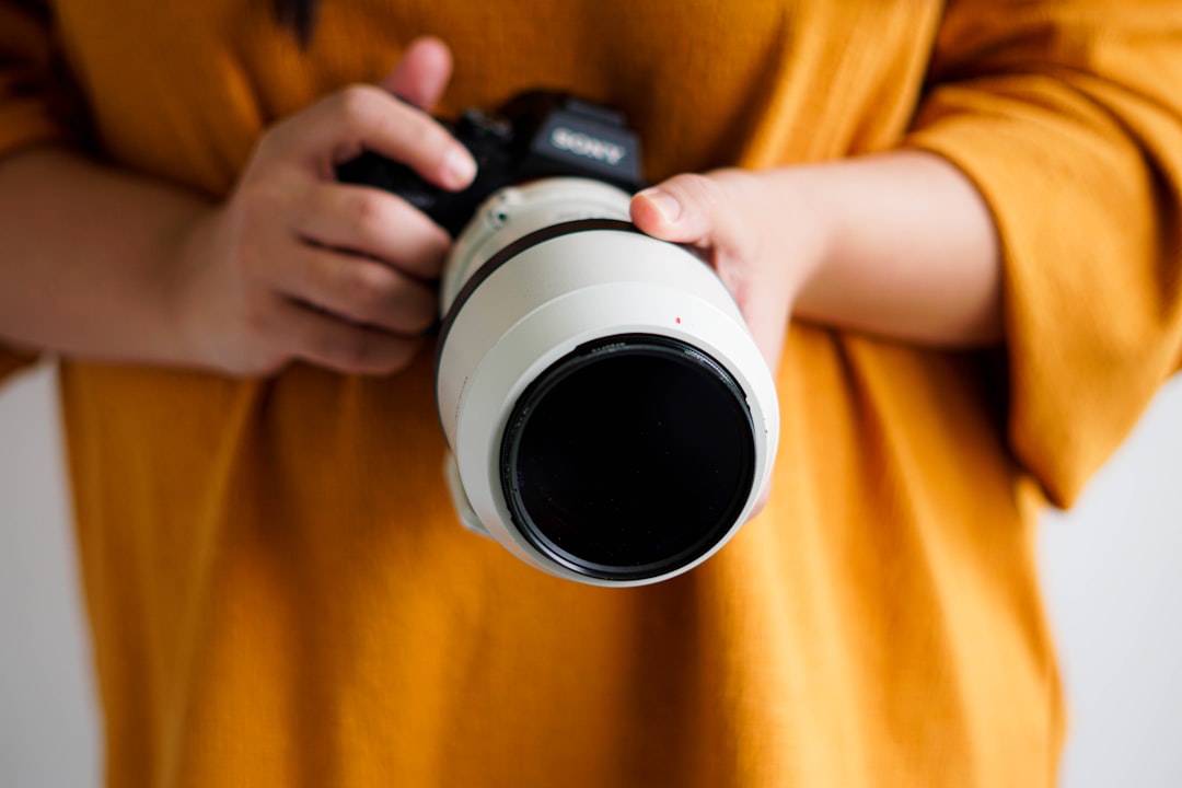 person holding white and black camera lens