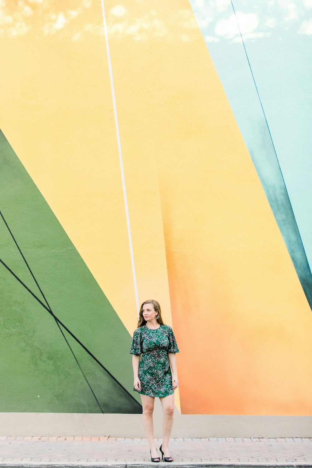 a woman standing in front of a colorful wall