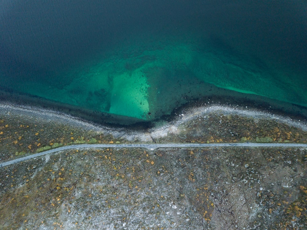 an aerial view of a road near a body of water