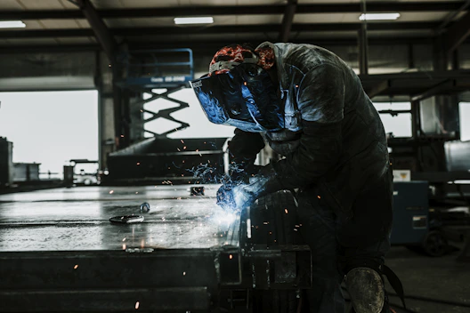 A skilled welder working on a metal fabrication project.