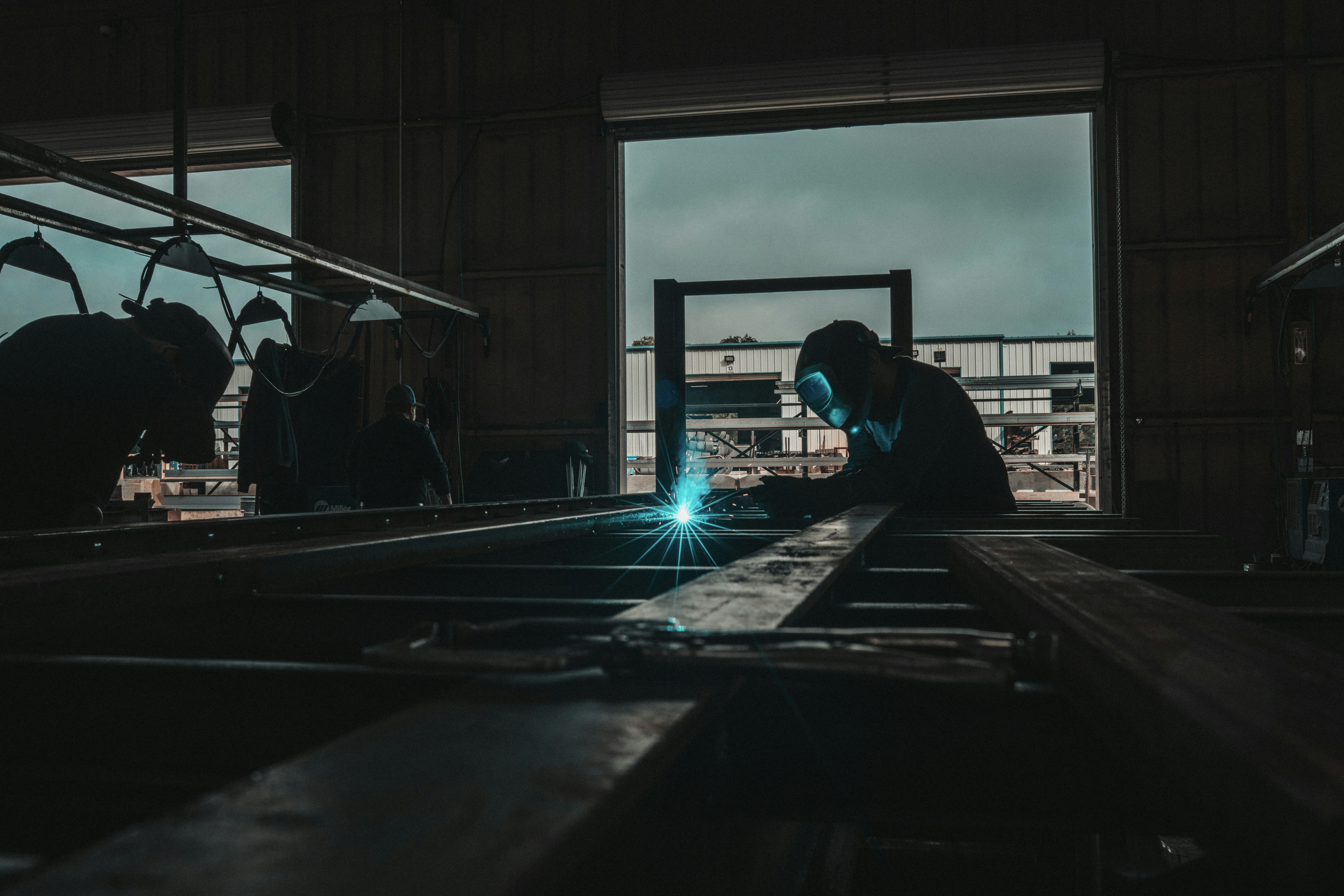 Mann in schwarzer Jacke vor schwarzem Flachbildschirm