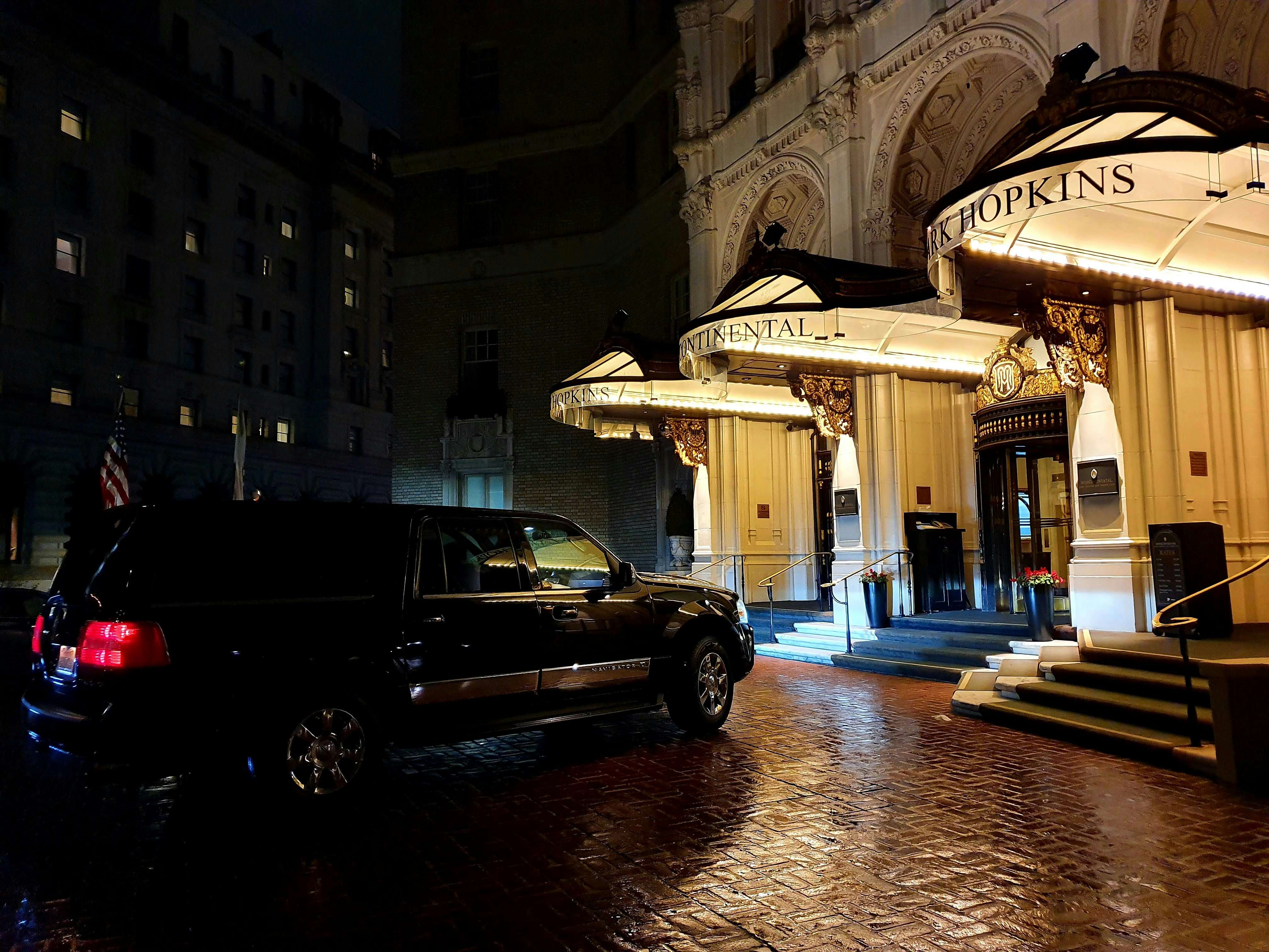 Black Cadillac Escalade SUV luxury vehicle parked at hotel entrance