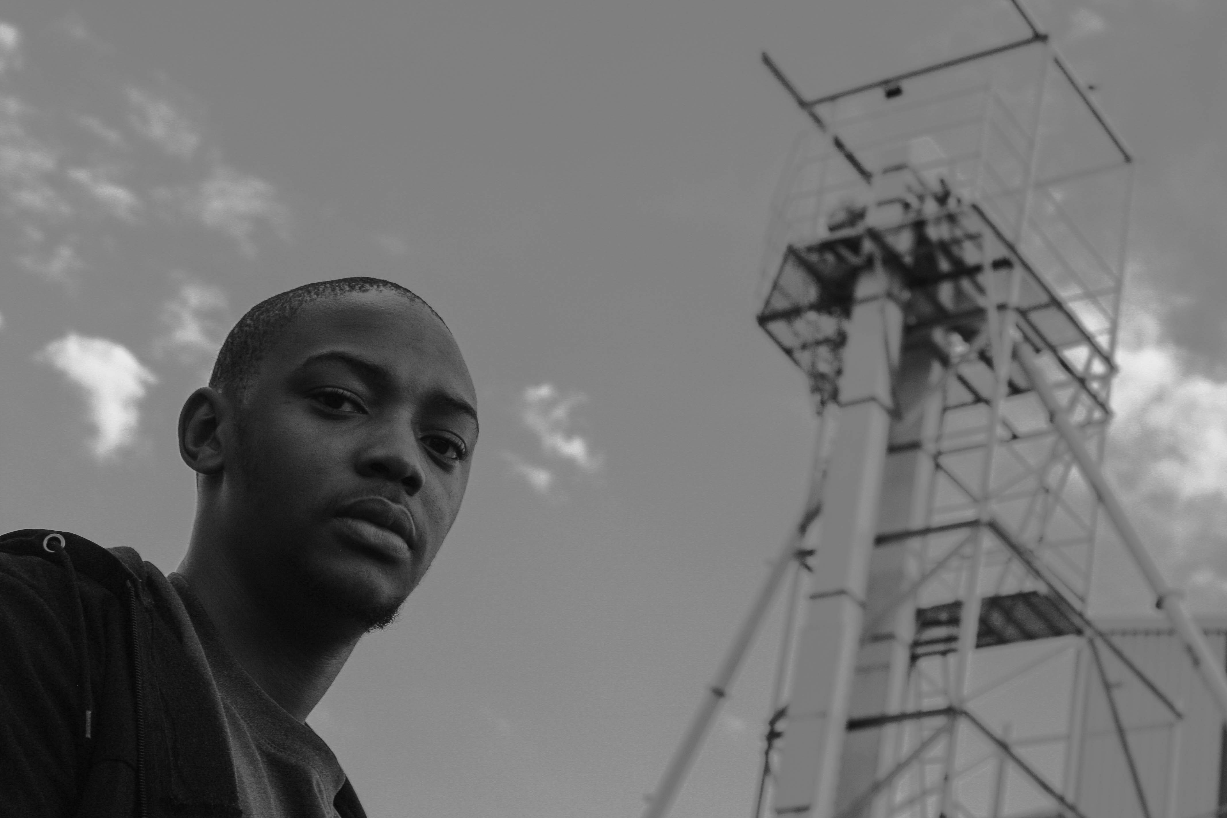 a man standing in front of a tall tower