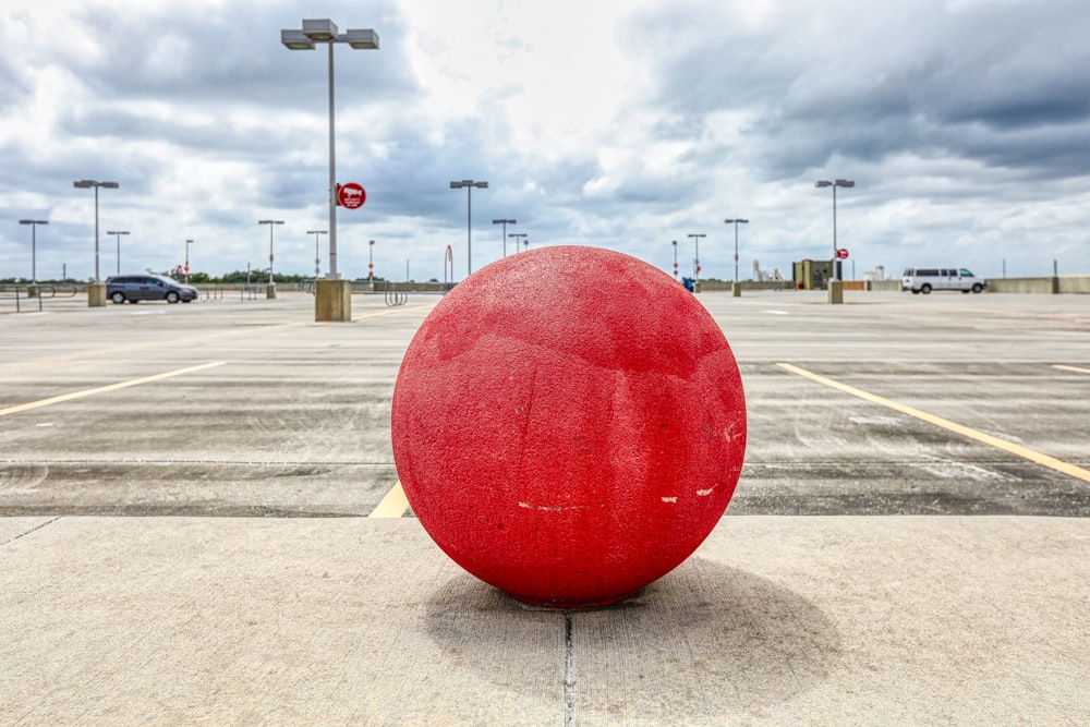 bola redonda roja en carretera de hormigón gris durante el día