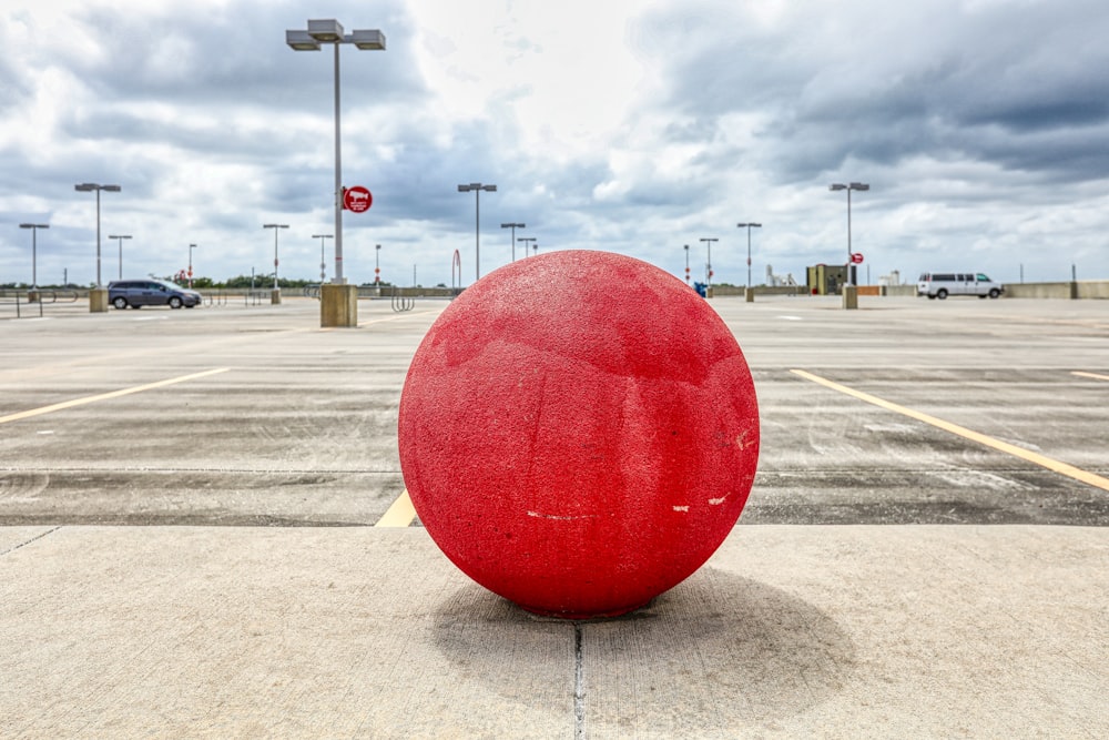 낮 동안 회색 콘크리트 도로에 빨간 둥근 공