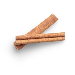 Two cinnamon sticks arranged diagonally against a white background. The texture of the bark is clearly visible, showcasing natural patterns.