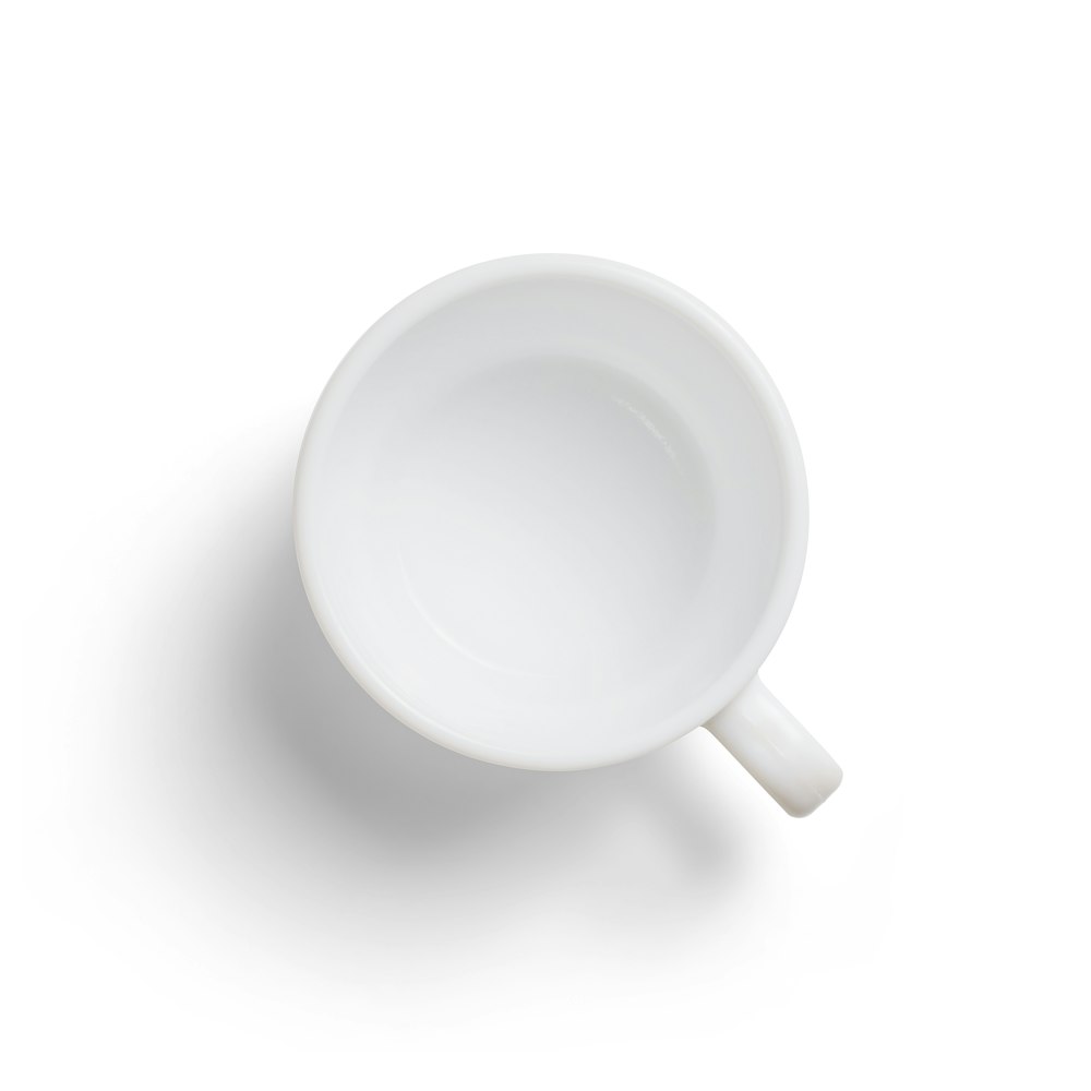white ceramic mug on white surface